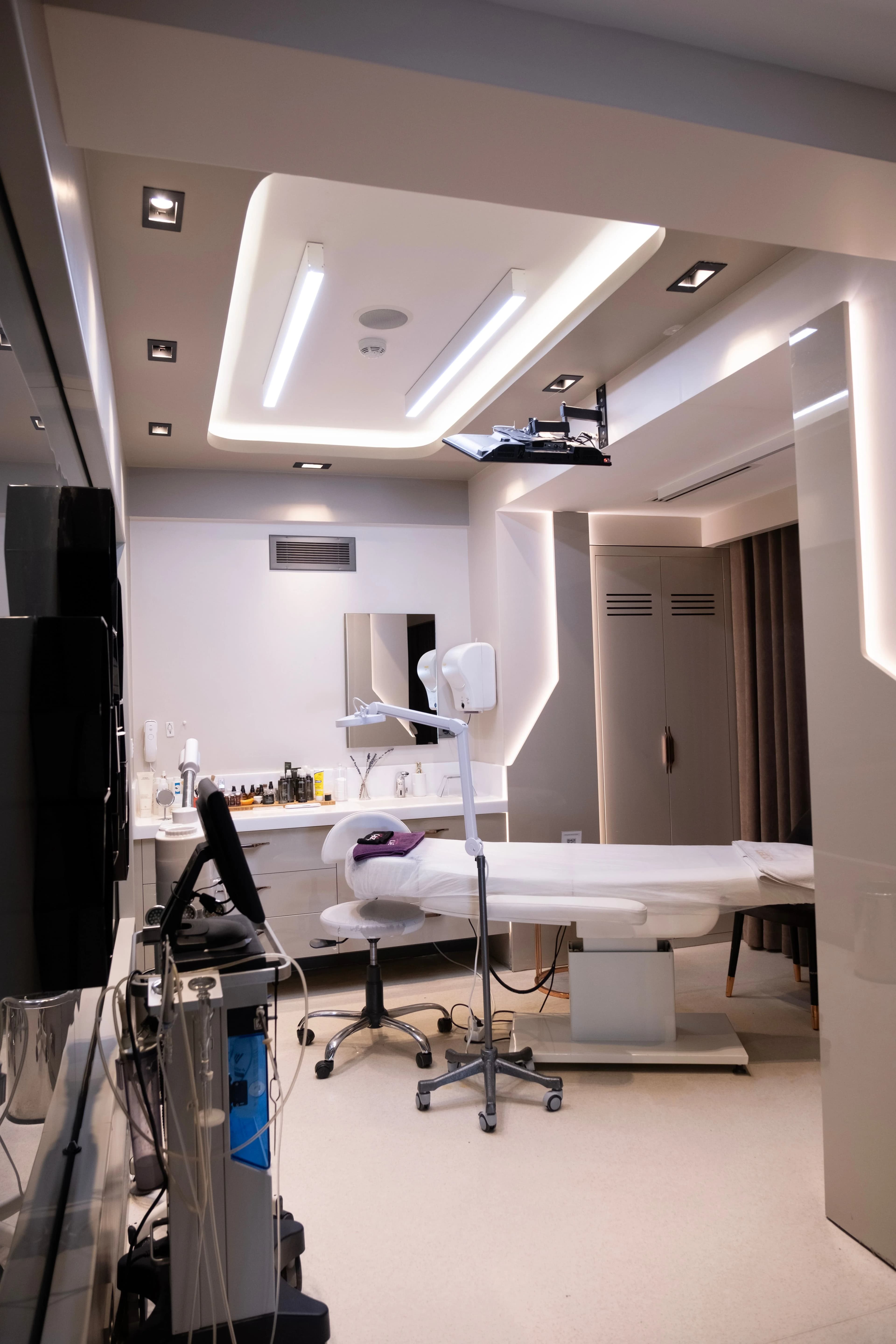 Modern med spa treatment room with a treatment bed and aesthetic equipment