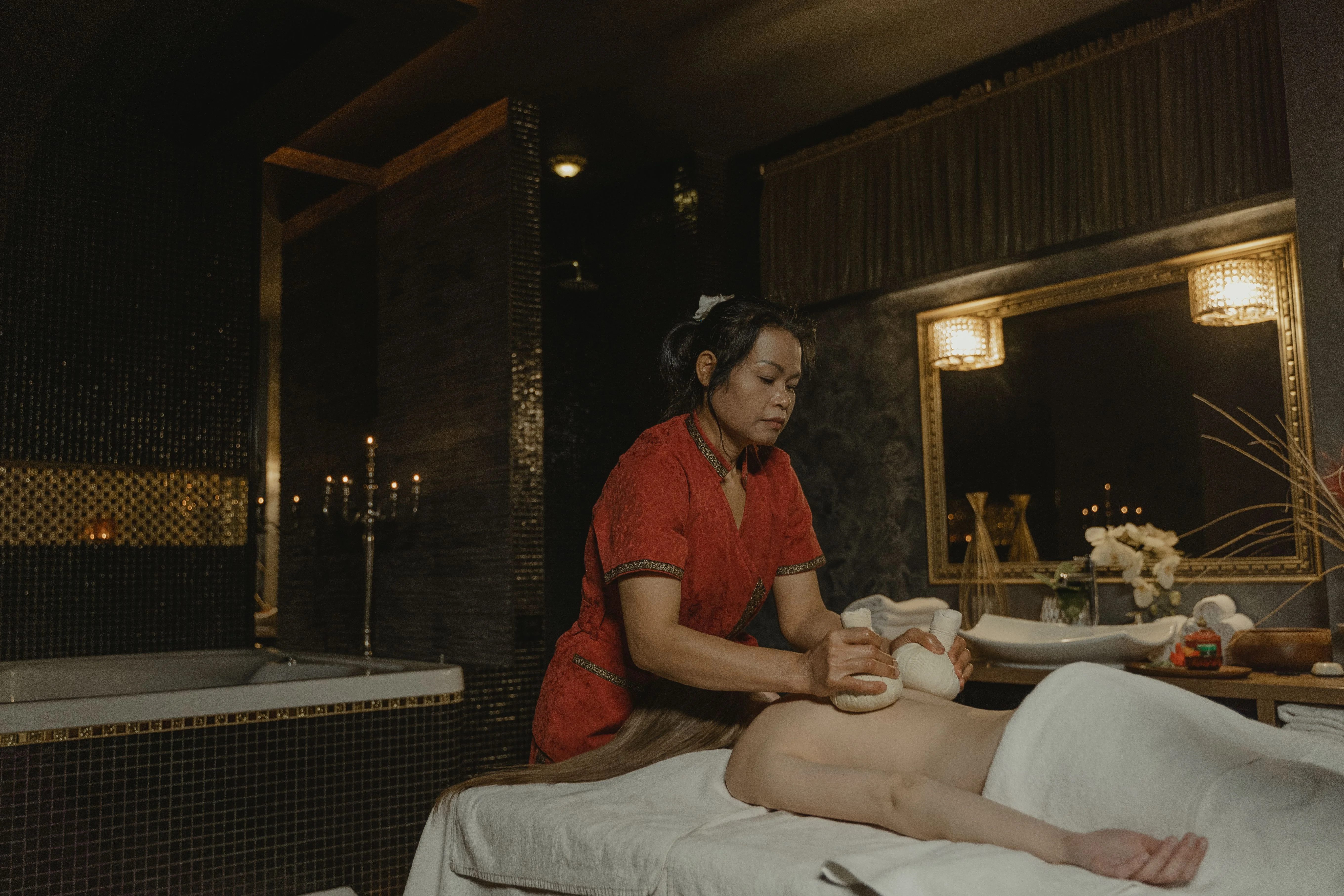 Licensed massage therapist giving a client a massage in a spa treatment room